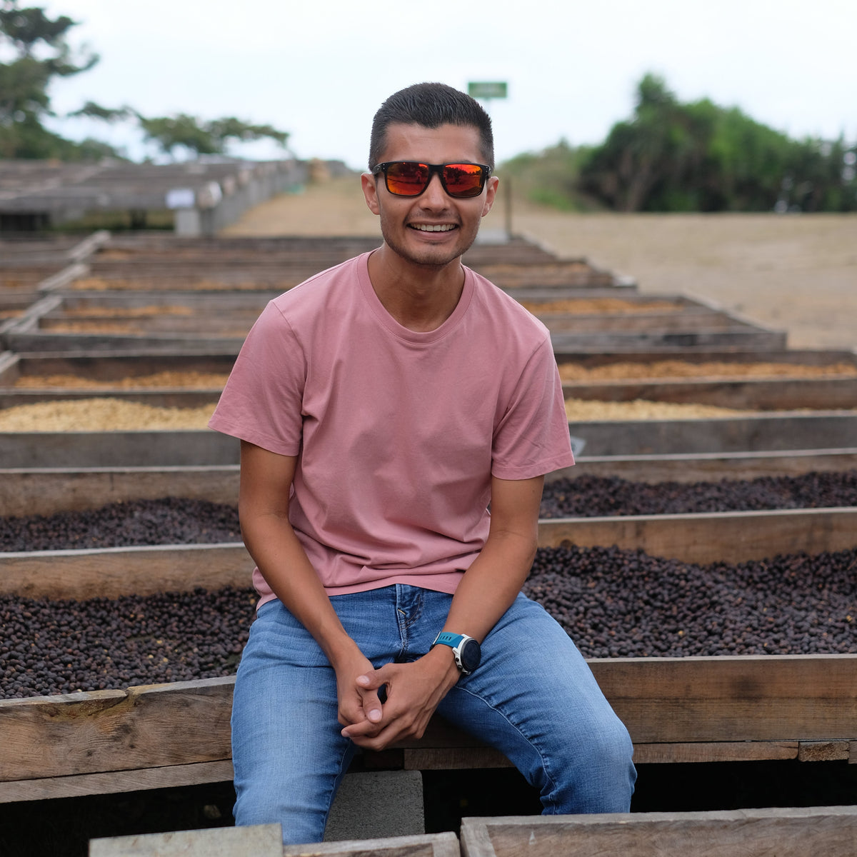 Person sitting on a wooden bench with a scenic background filled with coffee
