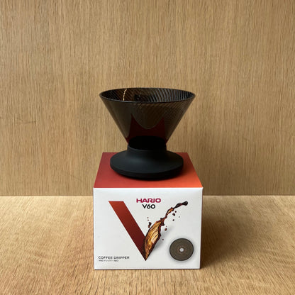HARIO V60 NEO coffee dripper displayed with elegant design and packaging on a wooden surface.