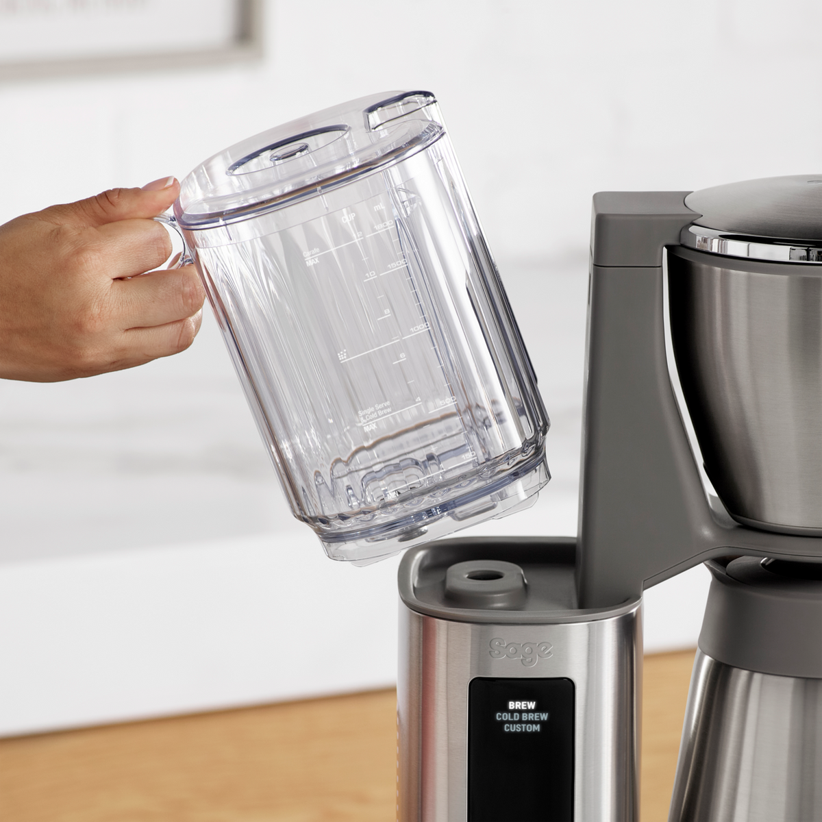 SAGE LUXE BREWER THERMAL hand holding clear water reservoir above the coffee maker.
