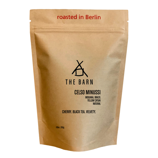 Kraft paper coffee bag with 'The Barn' branding and coffee description 'Celso Minussi' on a white background