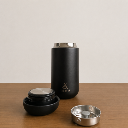 FELLOW CARTER MOVE TUMBLER in matte black with THE BARN logo, featuring a leak-proof lid and ceramic interior.