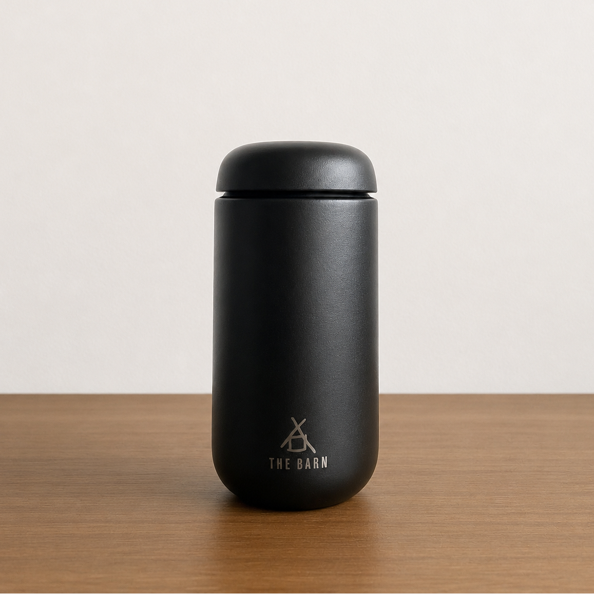 FELLOW CARTER MOVE TUMBLER with the THE BARN logo, matte black ceramic travel coffee mug for hot beverages.