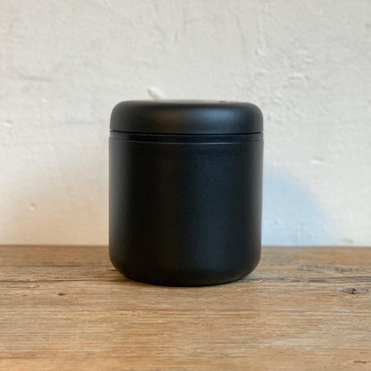 ATMOS ELECTRIC VACUUM CANISTER in matte black stainless steel on wooden surface.