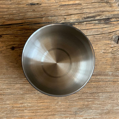 ATMOS ELECTRIC VACUUM CANISTER shown from above, highlighting durable stainless steel design on wood surface.